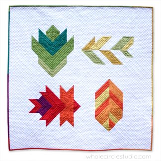 A fun, modern autumn wall hanging quilt or table runner! Leaf Peepers is a modern spin on the traditional half square triangle block. Join the sew along and quilt along and make this for your home or as a gift for Thanksgiving! Leah Day and Whole Circle Studio will walk you through all of the steps of this PDF pattern on their blogs. Add additional background fabric to make a larger quilt!